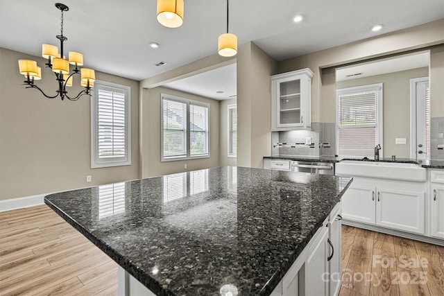 7362 Overjoyed Xing, Charlotte, NC 28215 - kitchen featuring a sink, a kitchen island, decorative backsplash, a chandelier, and light wood-style flooring