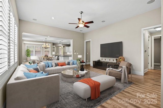 7362 Overjoyed Xing, Charlotte, NC 28215 - living room featuring light wood-type flooring, a chandelier, ceiling fan, baseboards, and recessed lighting