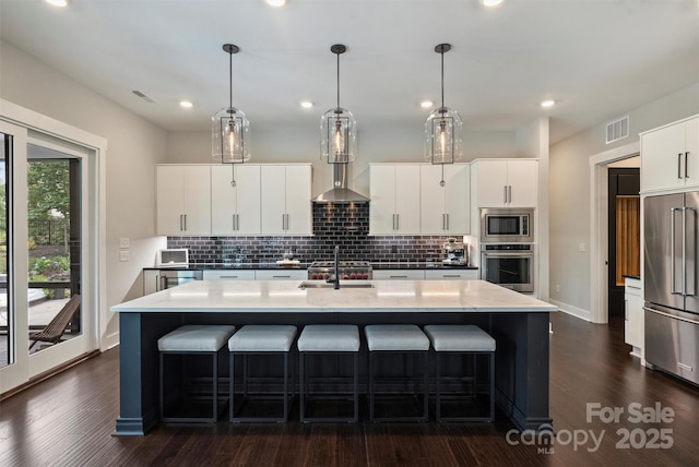 562 Preservation Dr, Fort Mill, SC 29715 - kitchen featuring stainless steel appliances, decorative backsplash, a center island with sink, a kitchen bar, and recessed lighting