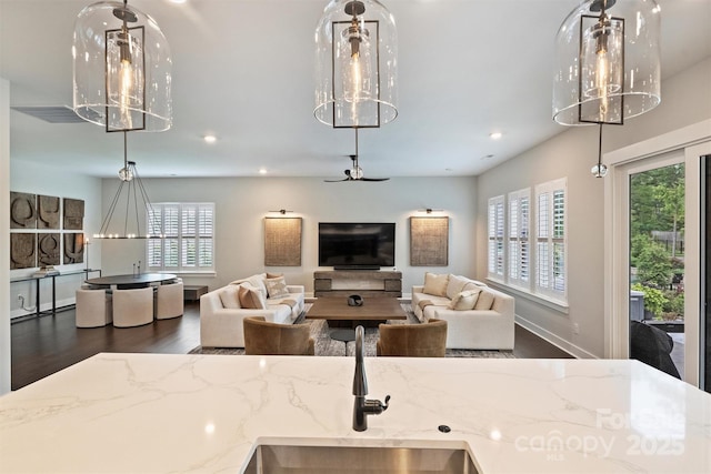 562 Preservation Dr, Fort Mill, SC 29715 - kitchen with wood finished floors, recessed lighting, a sink, light stone counters, and open floor plan