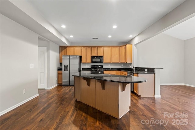 4095 Harmattan Dr, Denver, NC 28037 - kitchen with black appliances, a peninsula, a breakfast bar area, recessed lighting, and dark wood-type flooring