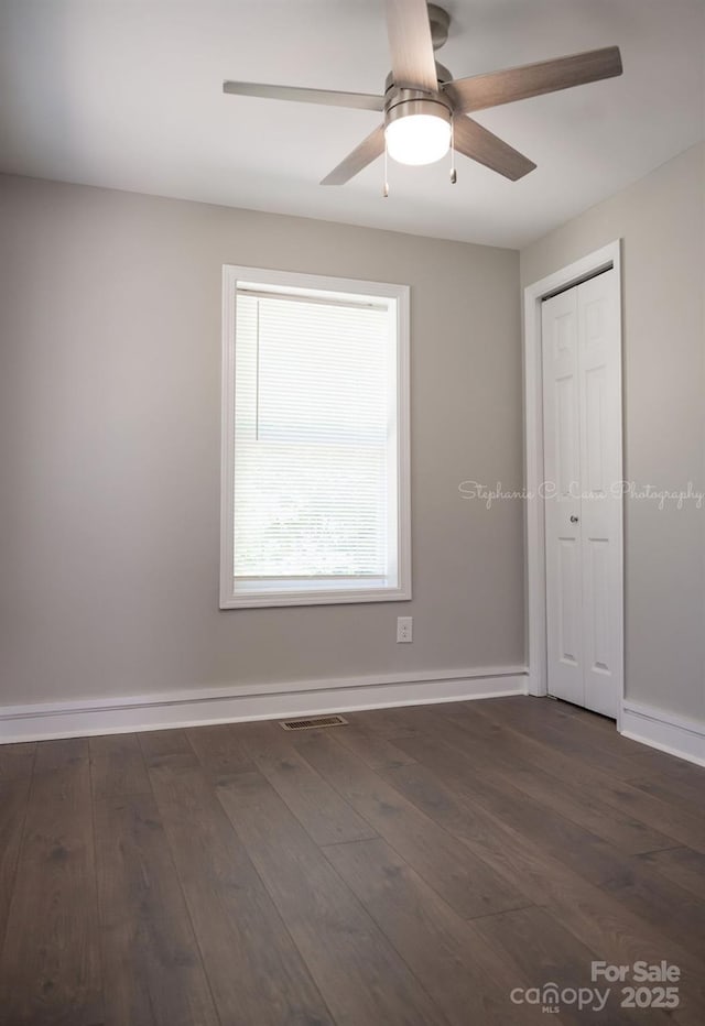728 Morningside Dr, Mount Holly, NC 28120 - unfurnished bedroom featuring dark wood-style flooring, a closet, baseboards, and ceiling fan
