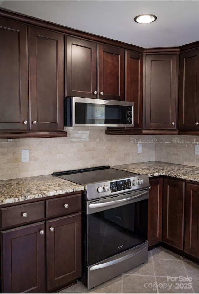 728 Morningside Dr, Mount Holly, NC 28120 - kitchen with stainless steel appliances, dark brown cabinetry, light stone countertops, and tasteful backsplash