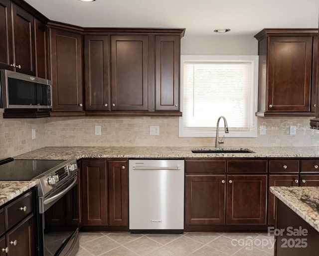 728 Morningside Dr, Mount Holly, NC 28120 - kitchen featuring appliances with stainless steel finishes, a sink, dark brown cabinets, tasteful backsplash, and light stone countertops