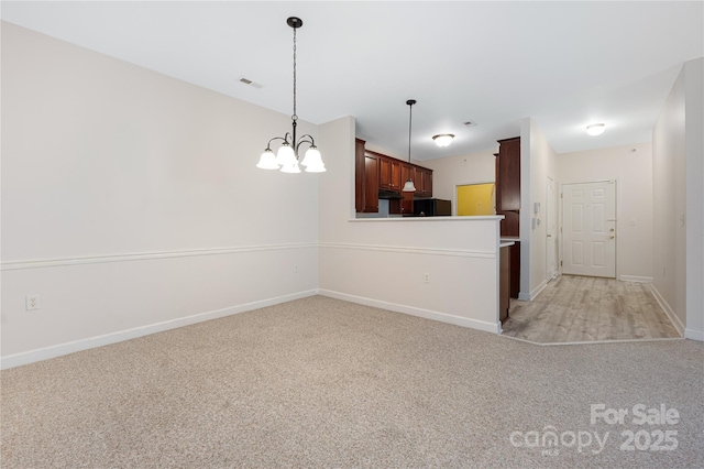 17111 Doe Valley Ct, Cornelius, NC 28031 - kitchen with light carpet, refrigerator, a chandelier, baseboards, and pendant lighting