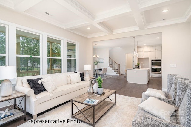 living room featuring dark wood-style flooring, beamed ceiling, coffered ceiling, ornamental molding, and a chandelier