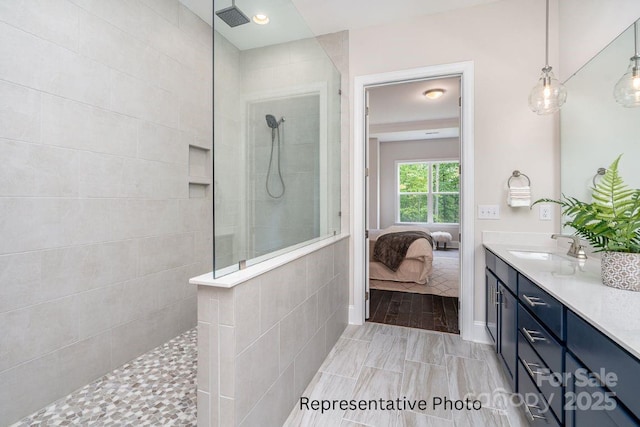 bathroom with walk in shower, vanity, and ensuite bathroom