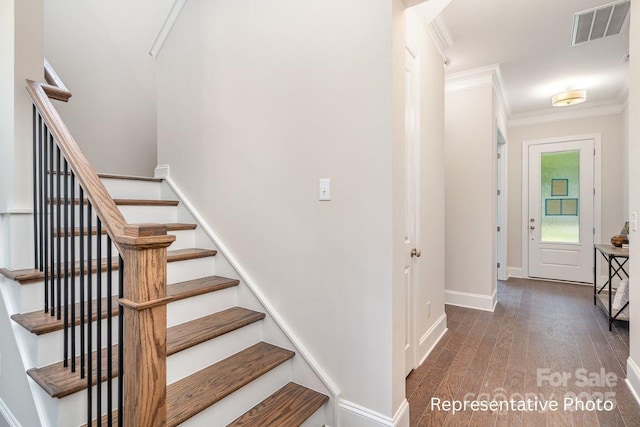 stairs featuring ornamental molding, hardwood / wood-style floors, and baseboards