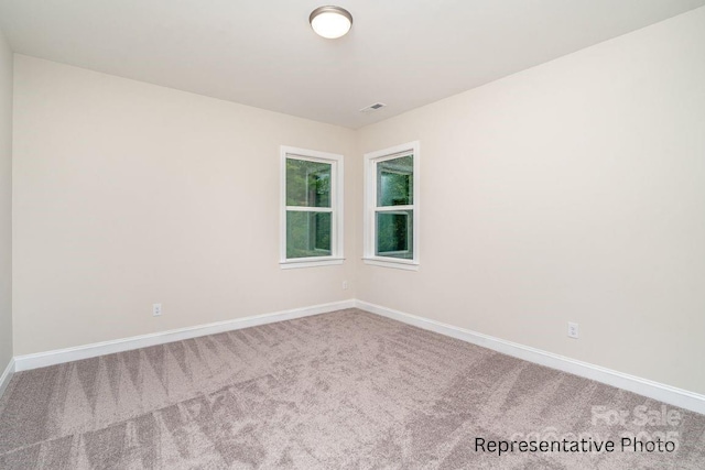 empty room featuring carpet and baseboards