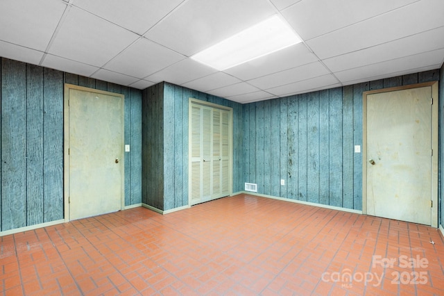 4306 Joplin Rd, Hudson, NC 28638 - empty room with a paneled ceiling, brick patterned floors, and wooden walls