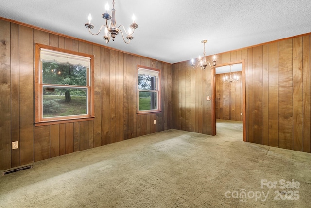 4306 Joplin Rd, Hudson, NC 28638 - unfurnished dining area with a chandelier, carpet floors, wooden walls, and a textured ceiling