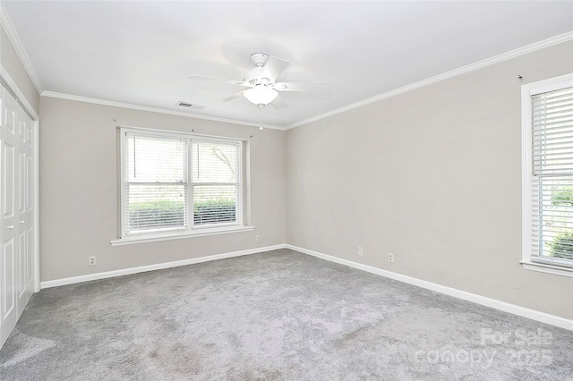 unfurnished bedroom featuring ornamental molding, carpet, baseboards, a closet, and a ceiling fan