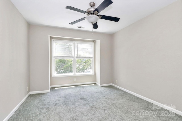 carpeted empty room with baseboards and a ceiling fan