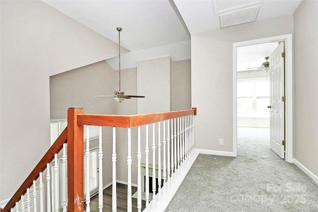 hall featuring attic access, baseboards, and carpet