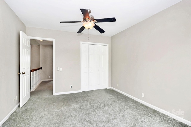 unfurnished bedroom with carpet floors, baseboards, a closet, and a ceiling fan