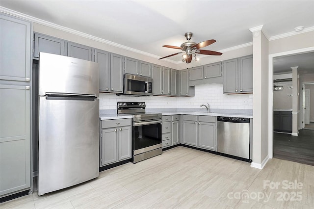 kitchen with stainless steel appliances, gray cabinetry, ceiling fan, light countertops, and tasteful backsplash