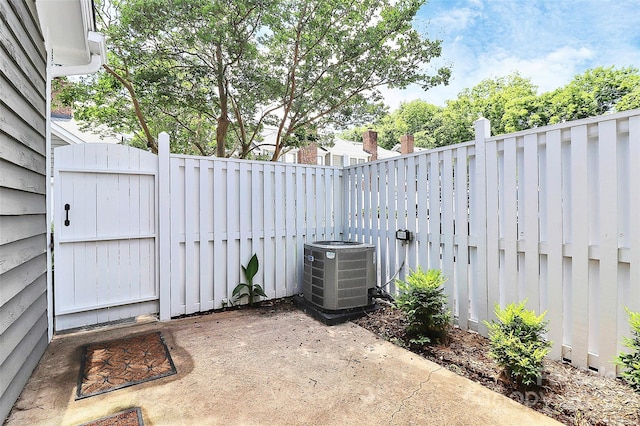 view of patio with central AC, fence, and a gate