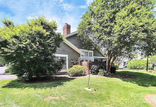 view of home's exterior featuring a lawn and a chimney