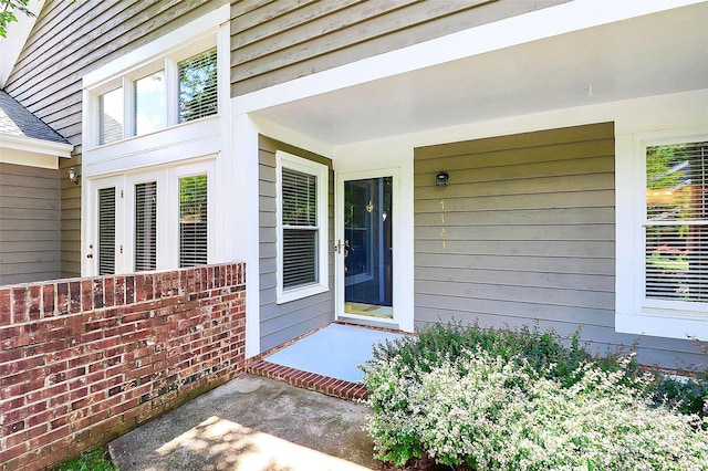 doorway to property featuring roof with shingles