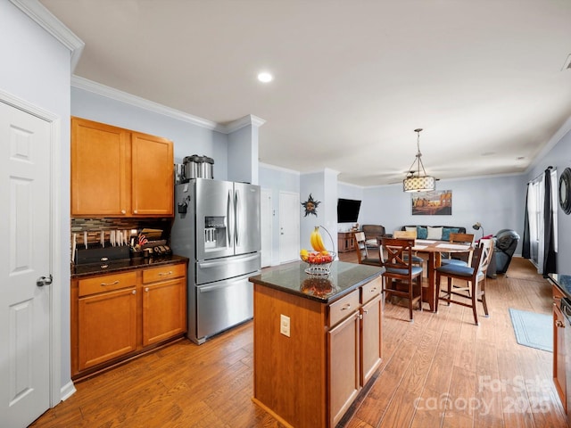5003 Singletree Ln, Indian Trail, NC 28079 - kitchen with stainless steel fridge, ornamental molding, open floor plan, light wood-style flooring, and a center island