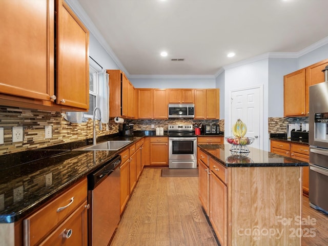 5003 Singletree Ln, Indian Trail, NC 28079 - kitchen with stainless steel appliances, ornamental molding, light wood-style floors, decorative backsplash, and a kitchen island
