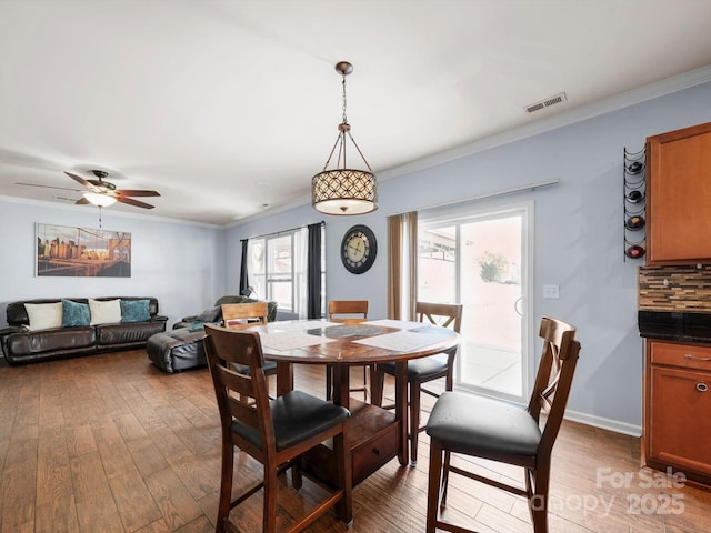 5003 Singletree Ln, Indian Trail, NC 28079 - dining area featuring light wood-style floors, crown molding, and ceiling fan