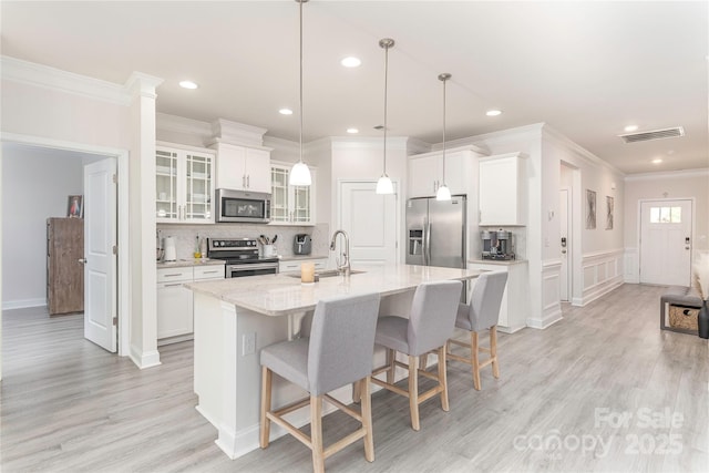 70 Rose Creek Rd, Leicester, NC 28748 - kitchen featuring stainless steel appliances, a sink, a kitchen bar, an island with sink, and white cabinetry