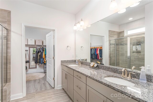 70 Rose Creek Rd, Leicester, NC 28748 - bathroom with a walk in closet, double vanity, a shower stall, and baseboards