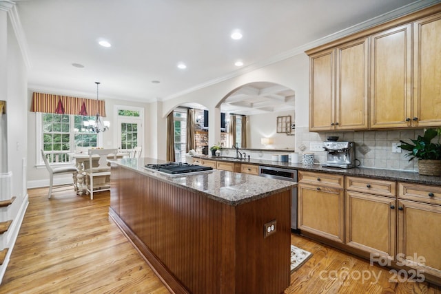 6795 Montgomery Rd, Lake Wylie, SC 29710 - kitchen with arched walkways, a kitchen island, stainless steel gas stovetop, crown molding, and light wood-style flooring