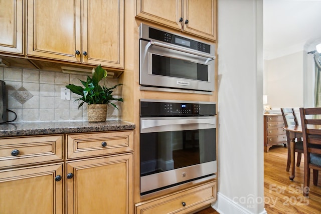 6795 Montgomery Rd, Lake Wylie, SC 29710 - kitchen with dark stone countertops, light wood-type flooring, tasteful backsplash, and stainless steel double oven