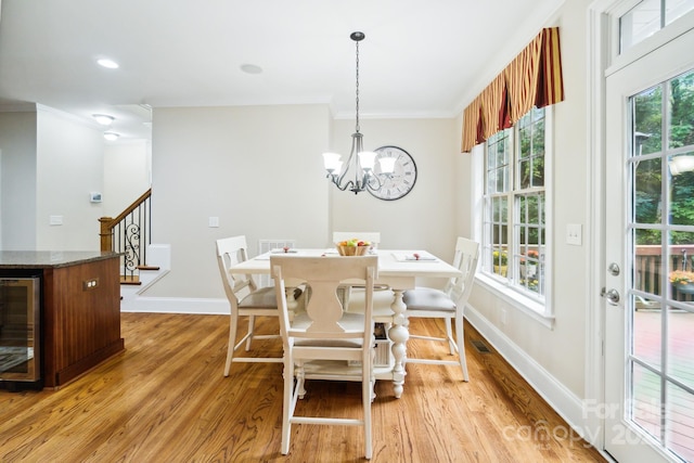 6795 Montgomery Rd, Lake Wylie, SC 29710 - dining area featuring beverage cooler, ornamental molding, stairs, baseboards, and light wood-type flooring