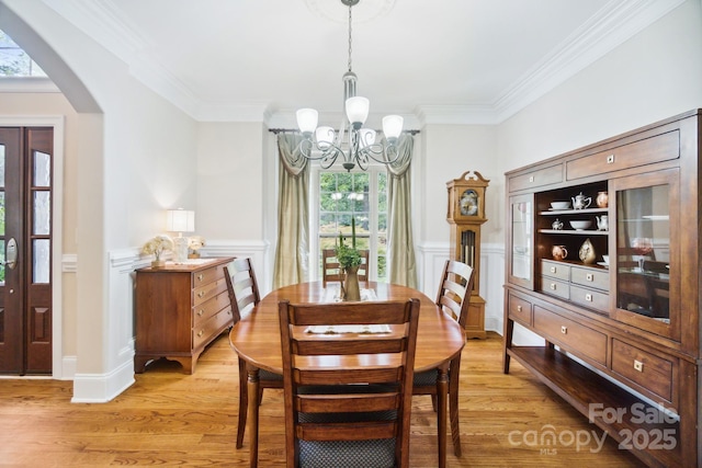 6795 Montgomery Rd, Lake Wylie, SC 29710 - dining area featuring a chandelier, arched walkways, healthy amount of natural light, light wood-type flooring, and ornamental molding