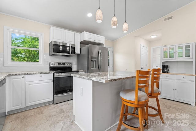 2315 Lanesboro Rd, Marshville, NC 28103 - kitchen with stainless steel appliances, white cabinetry, a center island, and a breakfast bar area