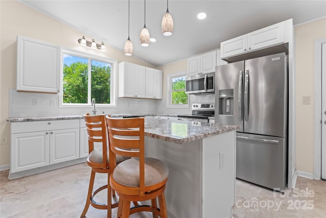 2315 Lanesboro Rd, Marshville, NC 28103 - kitchen featuring appliances with stainless steel finishes, decorative backsplash, light stone counters, white cabinets, and lofted ceiling