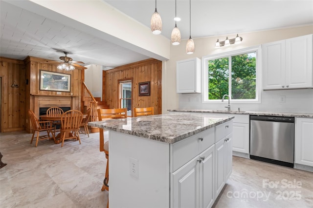 2315 Lanesboro Rd, Marshville, NC 28103 - kitchen featuring dishwasher, wooden walls, a sink, a ceiling fan, and light stone countertops