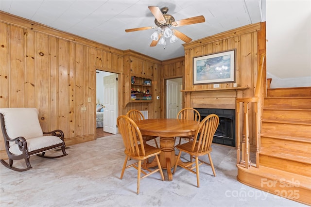 2315 Lanesboro Rd, Marshville, NC 28103 - dining space featuring wooden walls, stairway, a fireplace, a ceiling fan, and crown molding