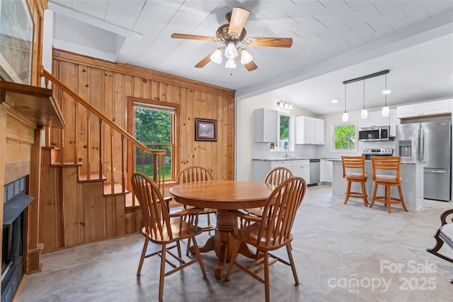 2315 Lanesboro Rd, Marshville, NC 28103 - dining space with wooden walls, a ceiling fan, lofted ceiling, stairway, and a fireplace