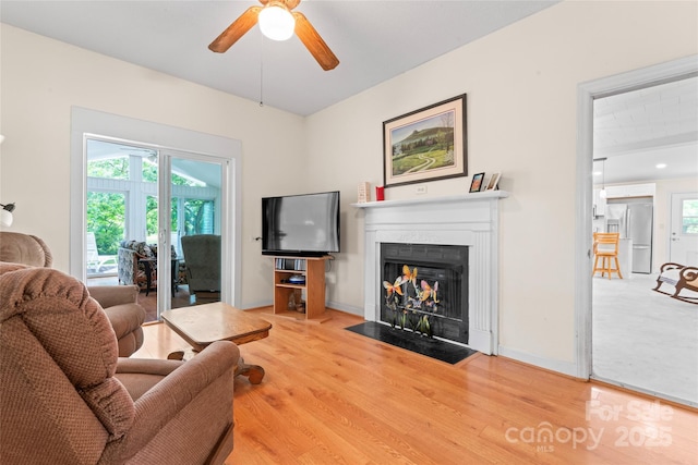 2315 Lanesboro Rd, Marshville, NC 28103 - living area featuring a ceiling fan, a fireplace with flush hearth, wood finished floors, and baseboards