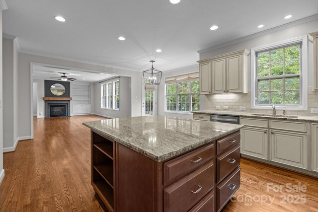 3206 Lakehurst Xing, Matthews, NC 28104 - kitchen with ornamental molding, light wood-style flooring, a sink, a center island, and tasteful backsplash