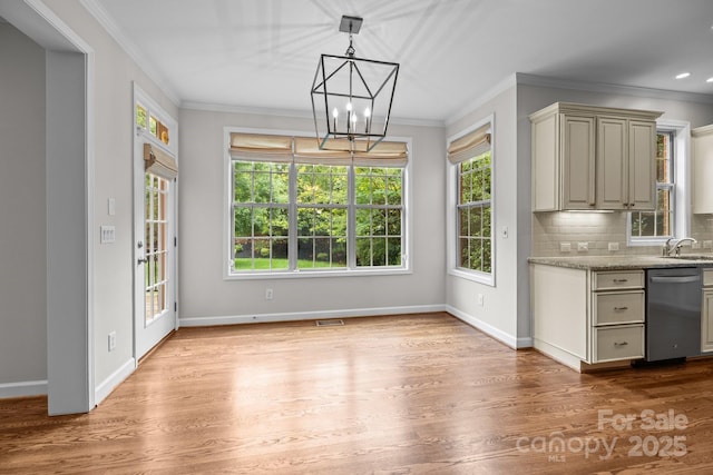 3206 Lakehurst Xing, Matthews, NC 28104 - unfurnished dining area with a chandelier, wood finished floors, ornamental molding, a sink, and baseboards