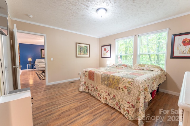 225 Opal Dr, Whittier, NC 28789 - bedroom featuring wood finished floors, a textured ceiling, baseboards, and crown molding