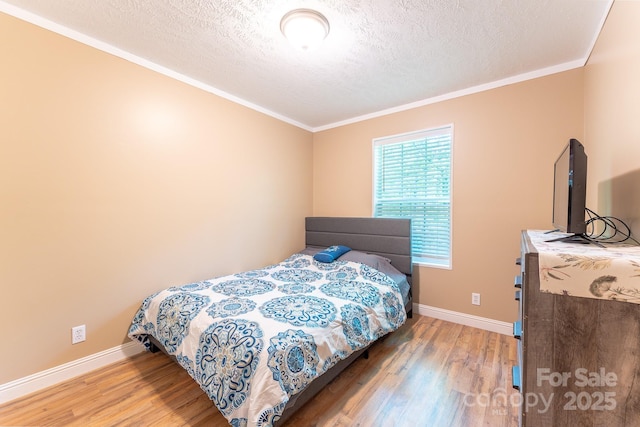 225 Opal Dr, Whittier, NC 28789 - bedroom featuring light wood finished floors, ornamental molding, a textured ceiling, and baseboards