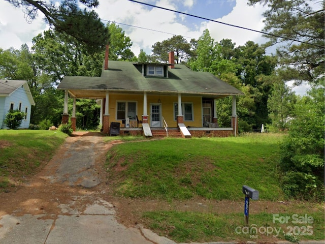 607 Lee Ave, Wadesboro, NC 28170 - view of front facade with a porch, asphalt driveway, a chimney, and a front yard