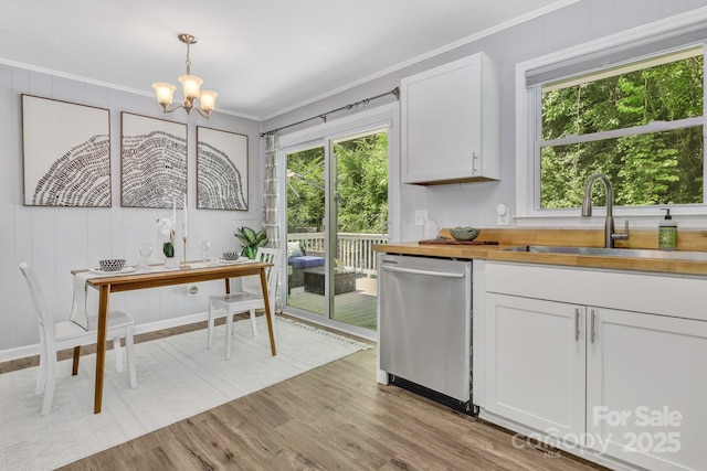 35 Avondale Rd, Asheville, NC 28803 - kitchen with stainless steel dishwasher, a sink, ornamental molding, butcher block countertops, and light wood-type flooring