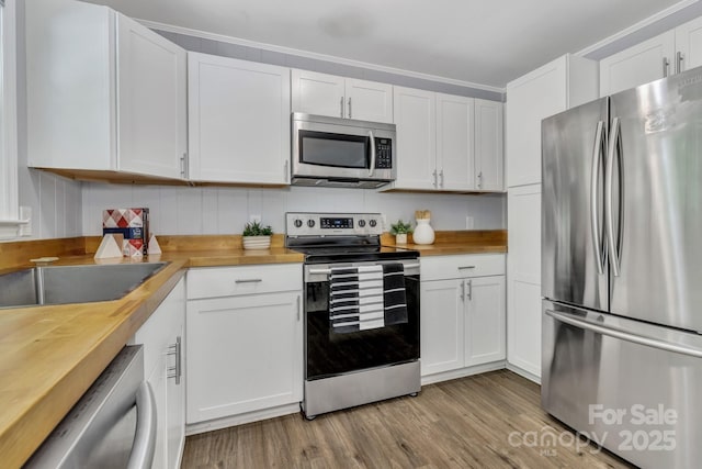 35 Avondale Rd, Asheville, NC 28803 - kitchen featuring appliances with stainless steel finishes, wood counters, white cabinetry, and light wood-type flooring