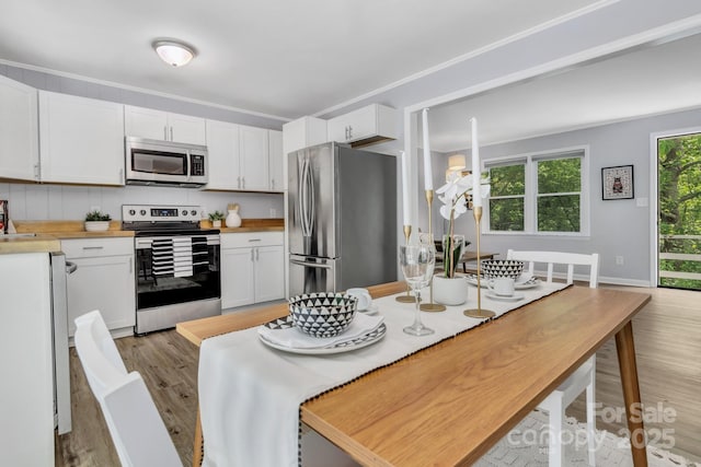 35 Avondale Rd, Asheville, NC 28803 - kitchen with appliances with stainless steel finishes, light wood-type flooring, white cabinets, and wood counters