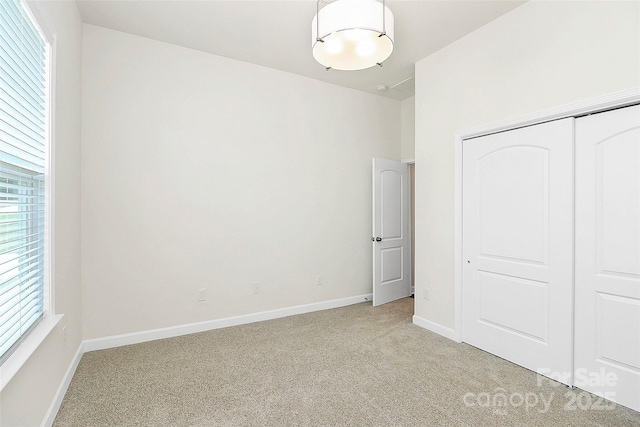 163 Crenshaw Pl NW, Concord, NC 28027 - unfurnished bedroom with light carpet, baseboards, and a closet