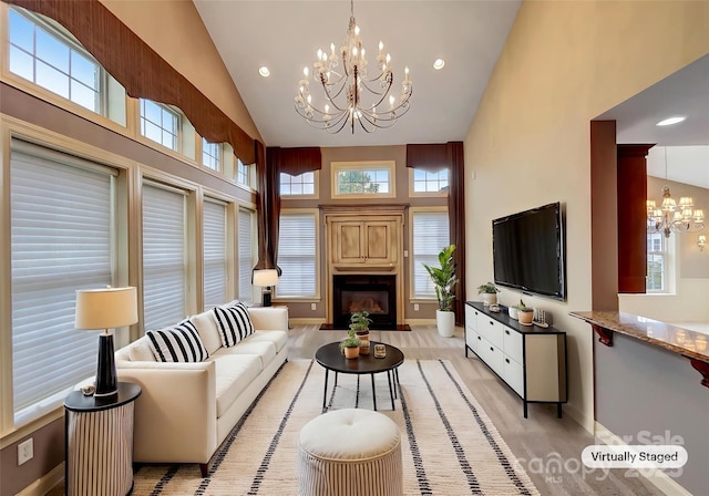 living room with a chandelier, high vaulted ceiling, baseboards, a fireplace, and recessed lighting