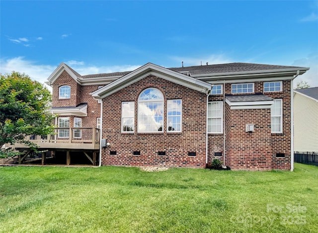 back of property featuring crawl space, brick siding, a deck, and a yard