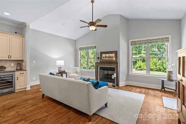 6211 Cruden Bay Way, Charlotte, NC 28277 - living area featuring beverage cooler, a fireplace, ceiling fan, lofted ceiling, and light wood-type flooring